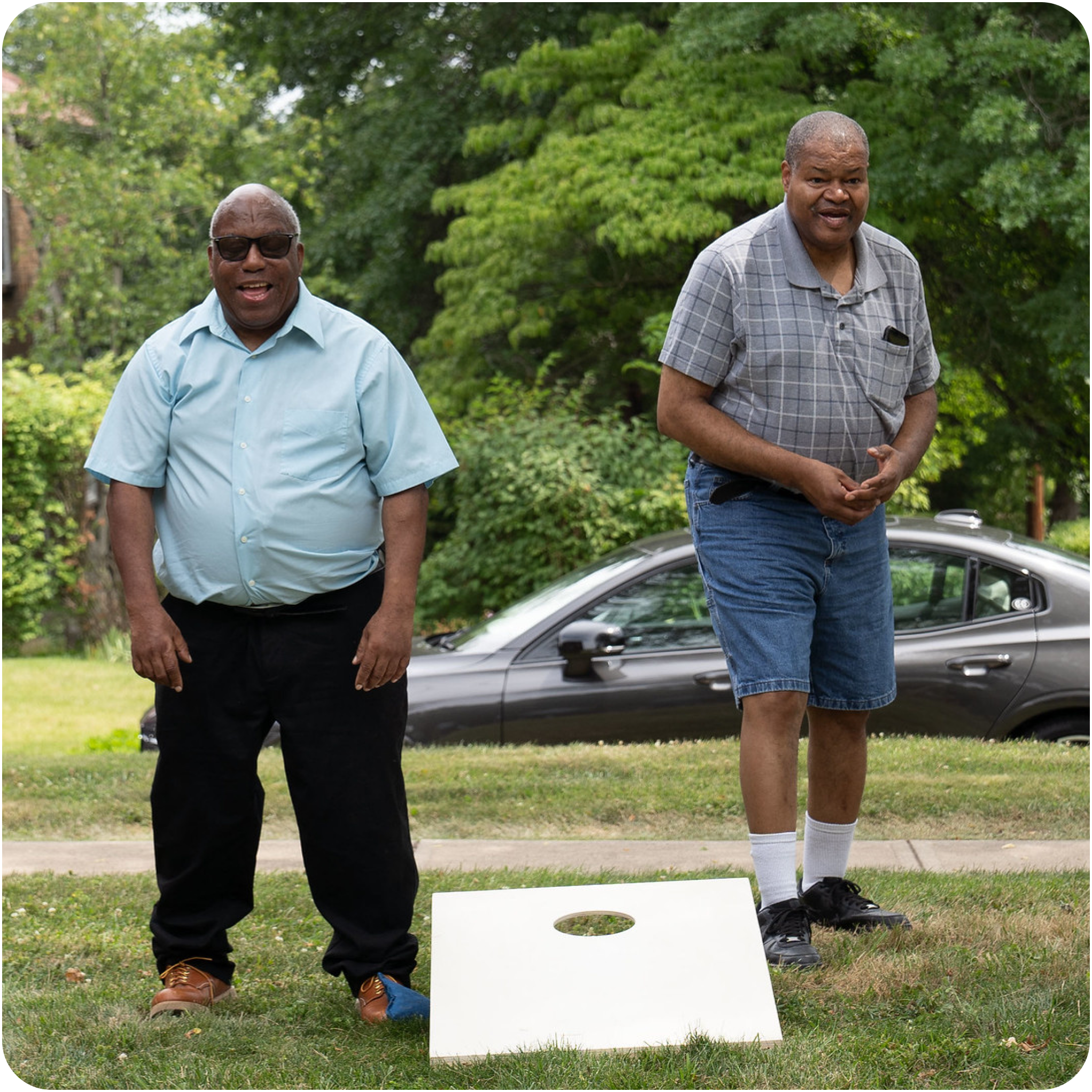 Two men playing cornhole at an outdoor event Two men playing cornhole at an outdoor event